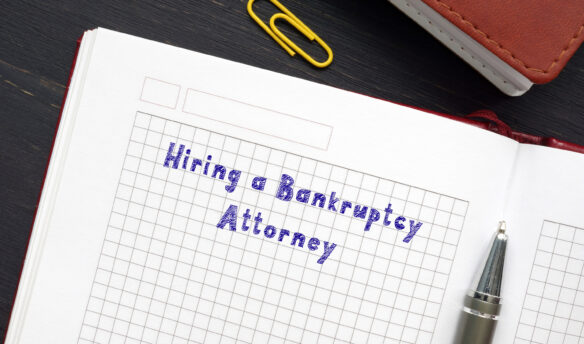 Hiring a Bankruptcy Attorney written on notebook with pen