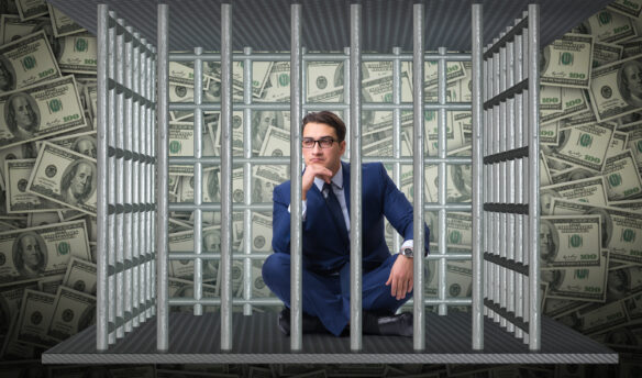 Man sitting behind bars feeling jailed by debt